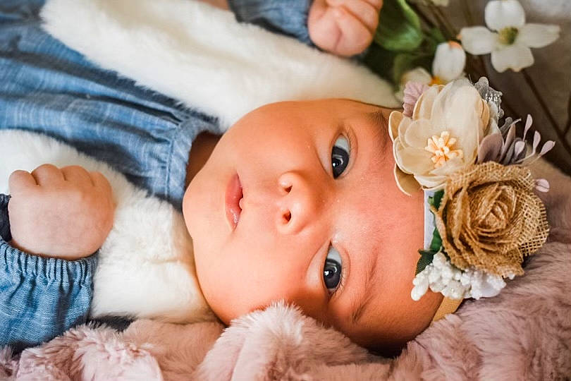 Kinleigh joined the competition — help win amazing prizes! baby, baby_toddler_clothing, cheek, dress, eye, eyelash, facial_expression, flower, hand, happy, head, headgear, headpiece, headwear, iris, lip, person, petal, pink, plant
