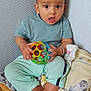 baby, child, toy, ball, wicker_basket, blanket, indoor, curious, wide_eyes, sitting, clothing, foot, hand, person, cute, playful, soft_lighting, expression, casual, home