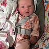 baby, infant, child, onesie, blanket, baby_seat, floral_pattern, straps, colorful, cute, newborn, soft, comfortable, indoors, portrait, looking_at_camera, pink, sleepwear, toddler, face
