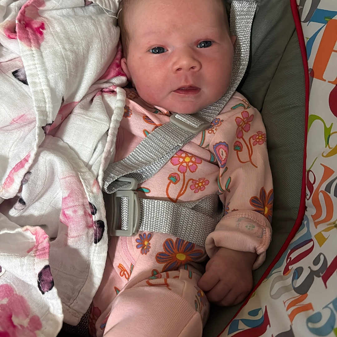 Lainey joined the competition — help win amazing prizes! baby, infant, child, onesie, blanket, baby_seat, floral_pattern, straps, colorful, cute, newborn, soft, comfortable, indoors, portrait, looking_at_camera, pink, sleepwear, toddler, face