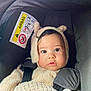 baby, child, car_seat, fuzzy_costume, bear_ears, wide_eyes, curious, pout, black_strap, airbag_warning, indoor, portrait, cute, infant, seatbelt, soft_texture, clothing, headwear, face, closeup