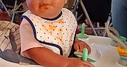 Kurakura is registered to the contest to win money with this photo: baby, baby_walker, bib, child, clothing, curious_expression, face, food_stains, furniture, hair_tie, hand, home, indoor, legs, messy_hair, person, playful, seat, toddler, wooden_floor