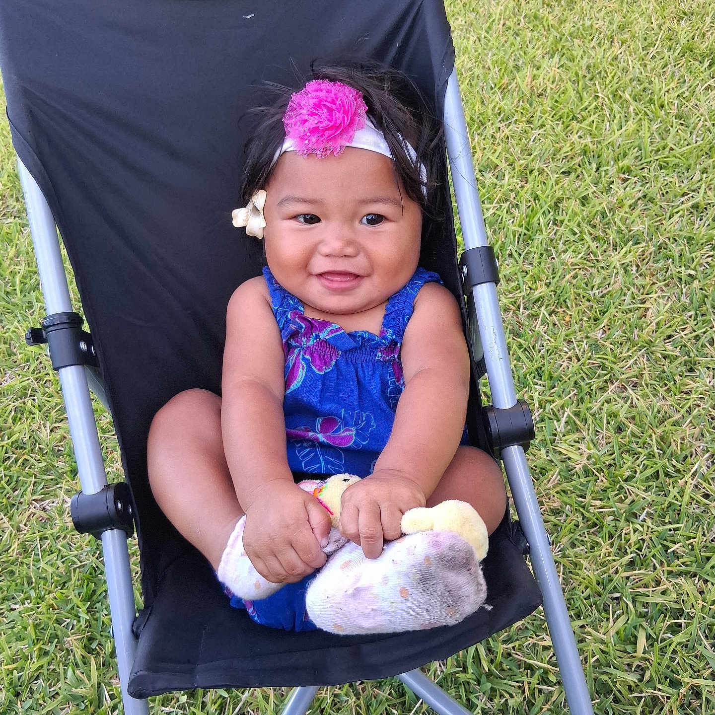 Kurakura is registered to the contest to win money with this photo: baby, child, smiling, outdoor, grass, chair, headband, flower, blue_clothing, sock, happy, person, infant, cute, seat, nature, playful, summer, skin, hand