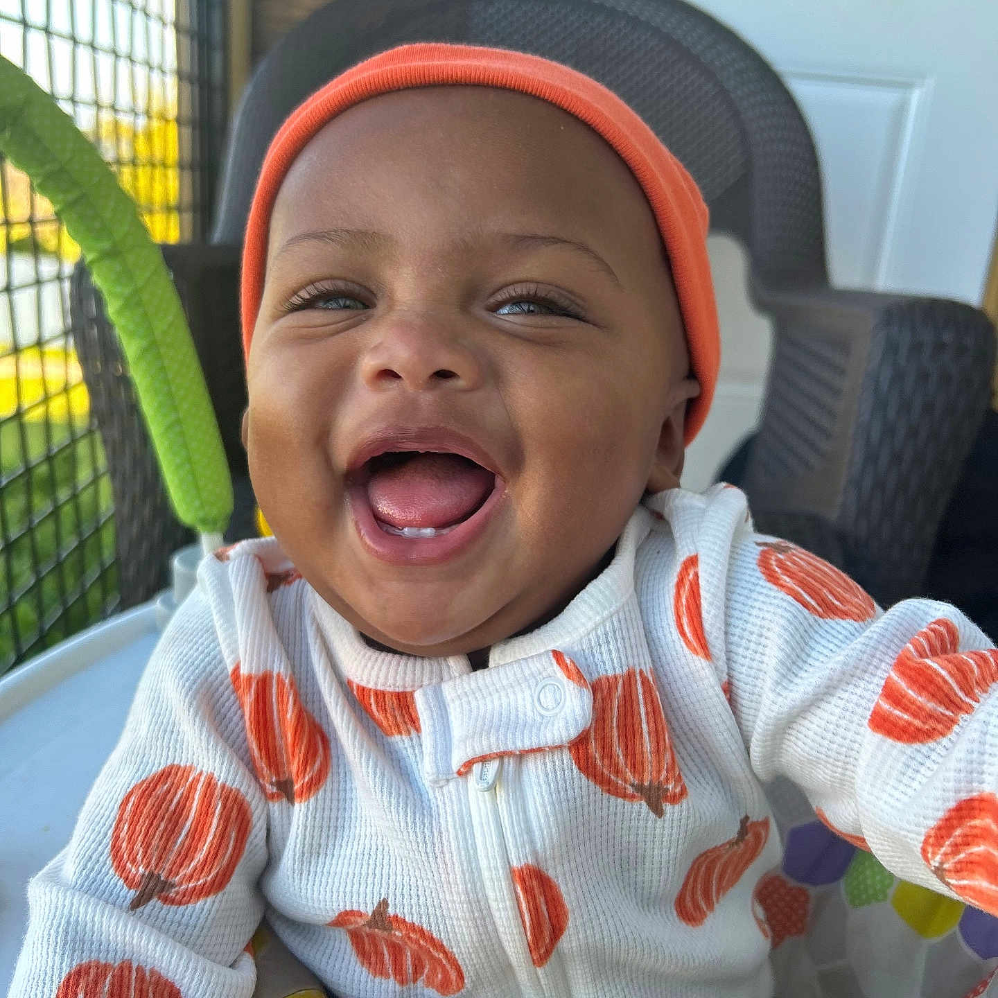 Kahlani is registered to the contest to win money with this photo: baby, baby_clothing, child, closeup, colorful, cute, happy, indoor, infant, joyful, netting, onesie, orange_beanie, play_seat, portrait, pumpkin_print, reaching_out, smiling, teeth, wicker_chair
