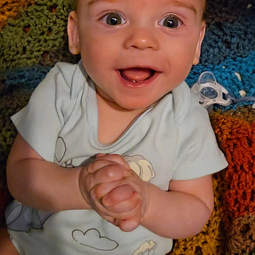 Oakley is registered to the contest to win money with this photo: accessories, baby, babylaughing, bodypart, bracelet, clothing, couch, face, finger, furniture, hand, happy, head, jewelry, laughing, person, photography, portrait, smile, t_shirt