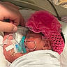 Evelyn is registered to the contest to win money with this photo: newborn, infant, baby, premature_baby, hospital, incubator, medical_equipment, pink_hat, crocheted_hat, flower_hat, blanket, swaddled, pacifier, breathing_tube, medical_tube, iv_line, adult_hand, sleeping, portrait, neonatal_care