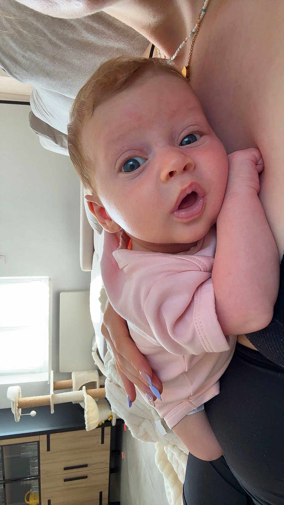 Ambre participe au concours pour gagner de l'argent avec cette photo : baby, child, infant, person, face, hand, skin, clothing, pink, nail_polish, furniture, sofa, couch, cat_tree, window, blanket, living_room, home, indoor, portrait