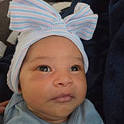 Lylah is registered to the contest to win money with this photo: baby, infant, child, portrait, face, eyes, hat, bow, striped_hat, pastel, blue, pink, clothing, blanket, closeup, indoors, sitting, looking_at_camera, cute, photography