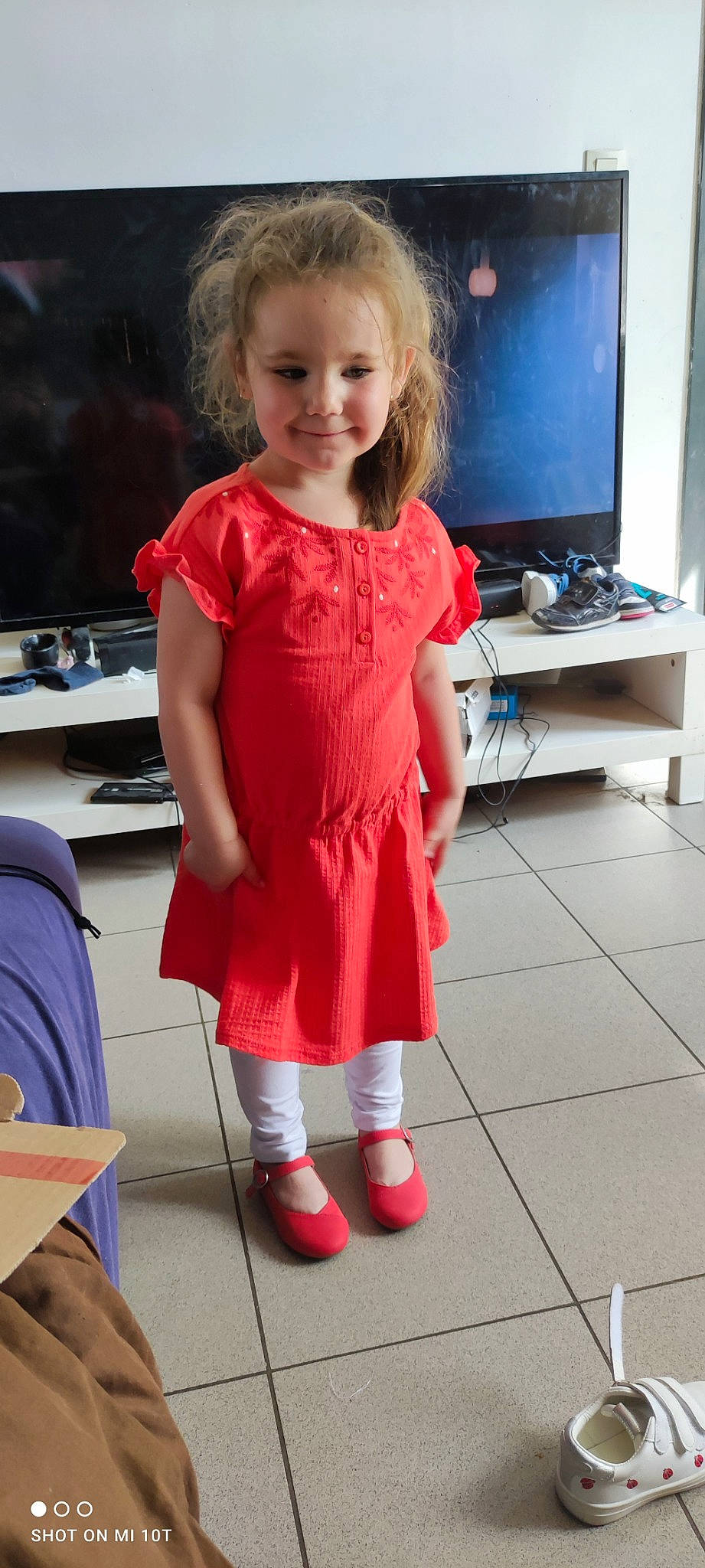 Alézia participe au concours pour gagner de l'argent avec cette photo : baby_toddler_clothing, blond, child, dress, event, flooring, hair, happy, human_leg, joint, joy, knee, person, shoe, sleeve, smile, sock, standing, television, thigh