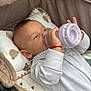 Damir participe au concours pour gagner de l'argent avec cette photo : baby, bottle, stroller, pillow, blanket, infant, sleepwear, bear_pattern, hand, face, child, white_clothing, red_bracelet, soft_toys, cuddly, resting, cute, comfortable, indoors, portrait