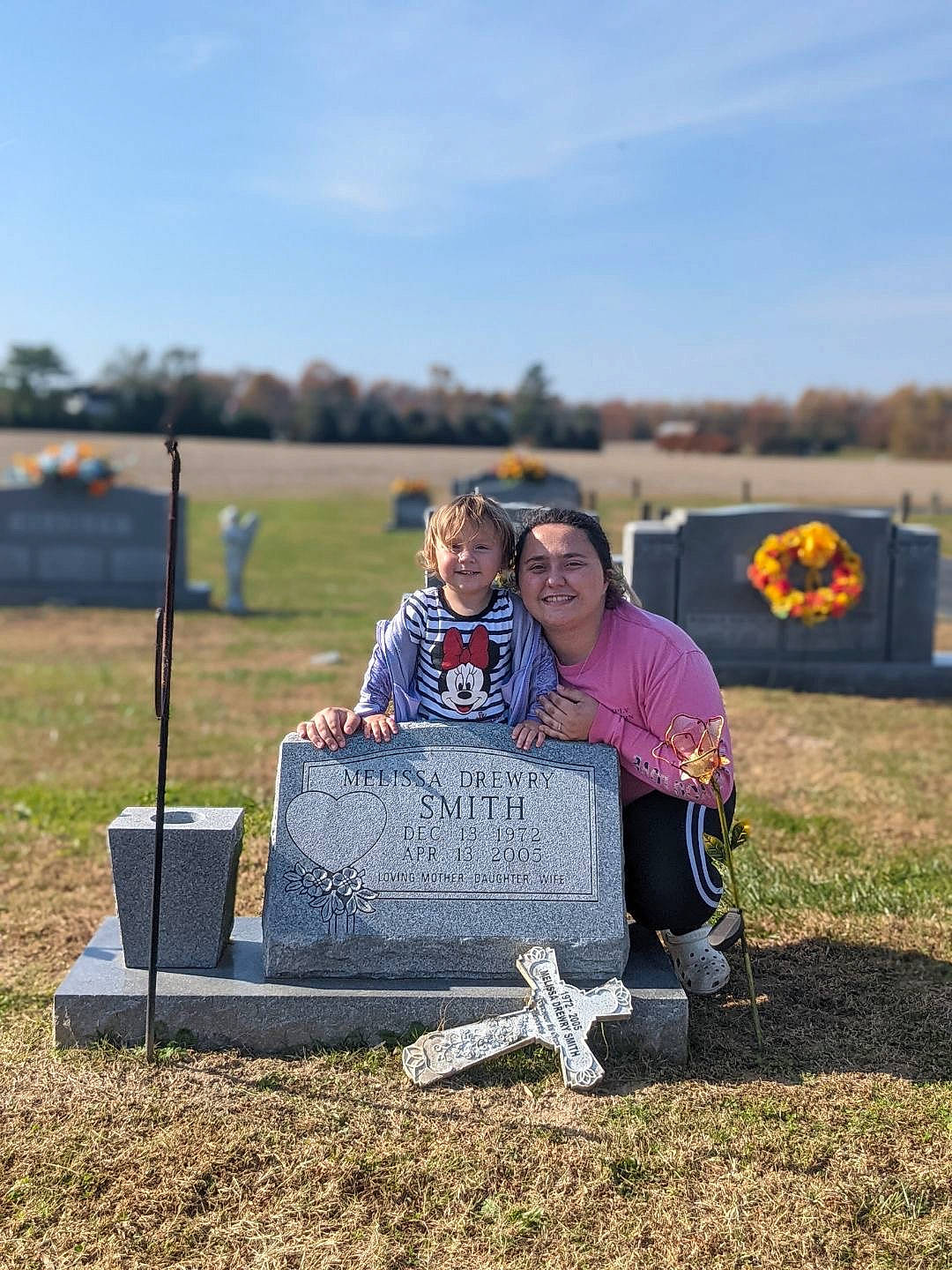 Melissa is registered to the contest to win money with this photo: cloud, event, fun, grass, grassland, grave, happy, jacket, joy, landscape, leisure, person, plant, prairie, recreation, sitting, sky, smile, soil, t_shirt