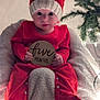 baby, blanket, child, christmas_tree, cozy, cute, festive, five_months, hat, holiday, indoor, infant, knit_hat, milestone, portrait, red_clothing, sitting, smiling, soft_lighting, wooden_sign