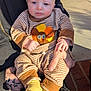 Slade is registered to the contest to win money with this photo: baby, brick, casual, child, concrete, cute, facial_expression, hand, holding, infant, outdoor, person, porch, sitting, striped_clothing, sunlight, tattoo, turkey_outfit, warm_light, yellow_socks