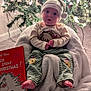 baby, blanket, book, carpet, child, christmas_tree, cozy, curious_expression, cute, decorations, dr_seuss, festive, hat, holiday, indoor, lights, pine_cones, seasonal, smiling, striped_pants