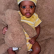 Markiem joined the competition — help win amazing prizes! baby, child, teddy_bear, yellow_clothing, hat, socks, blanket, soft_texture, indoor, cute, portrait, infant, person, smiling, seated, plush_toy, cozy, young, looking_at_camera, brown