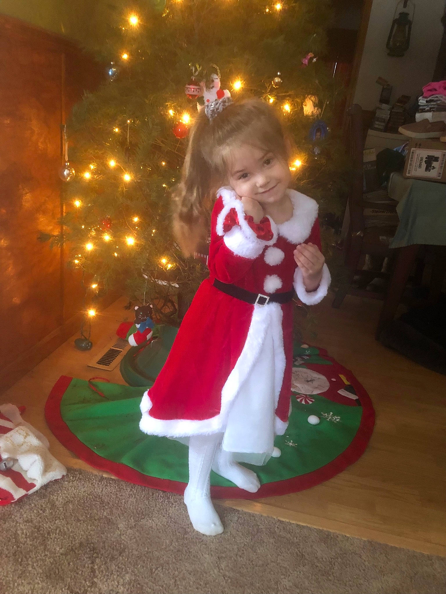 Annabelle is registered to the contest to win money with this photo: child, christmas, christmas_decoration, christmas_eve, christmas_ornament, christmas_tree, dress, event, fun, happy, holiday, holiday_ornament, interior_design, joy, lap, ornament, person, plant, sitting, smile