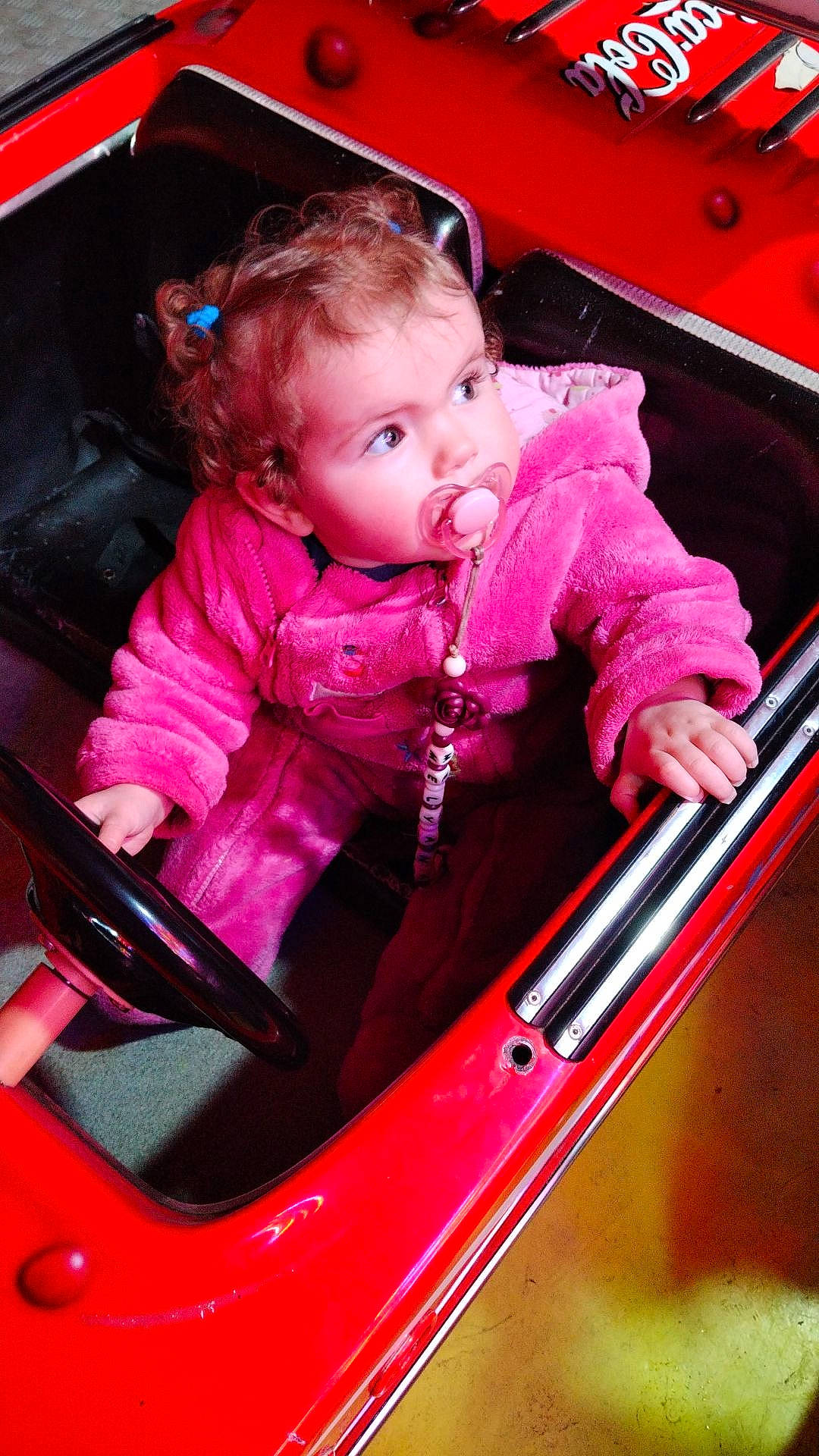 Mélyana participe au concours pour gagner de l'argent avec cette photo : automotive_design, automotive_exterior, baby, baby_toddler_clothing, bumper, cheek, child, fun, hood, magenta, mode_of_transport, motor_vehicle, person, photograph, pink, red, skin, snapshot, toddler, vehicle