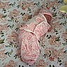 Addilyn is registered to the contest to win money with this photo: baby, newborn, infant, sleeping, swaddled, pink_clothing, crib, bedding, floral_pattern, nursery, plush_toy, stuffed_animal, portrait, indoors, resting, blanket, bonnet, cozy, face, child