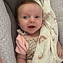 Mavie a rejoint le concours — aidez-le/la à gagner de superbes lots ! baby, blanket, child, closeup, comfortable, cushion, cute, expression, face, happy, head, indoors, infant, newborn, patterned_fabric, pink_clothing, portrait, resting, smiling, soft_toys