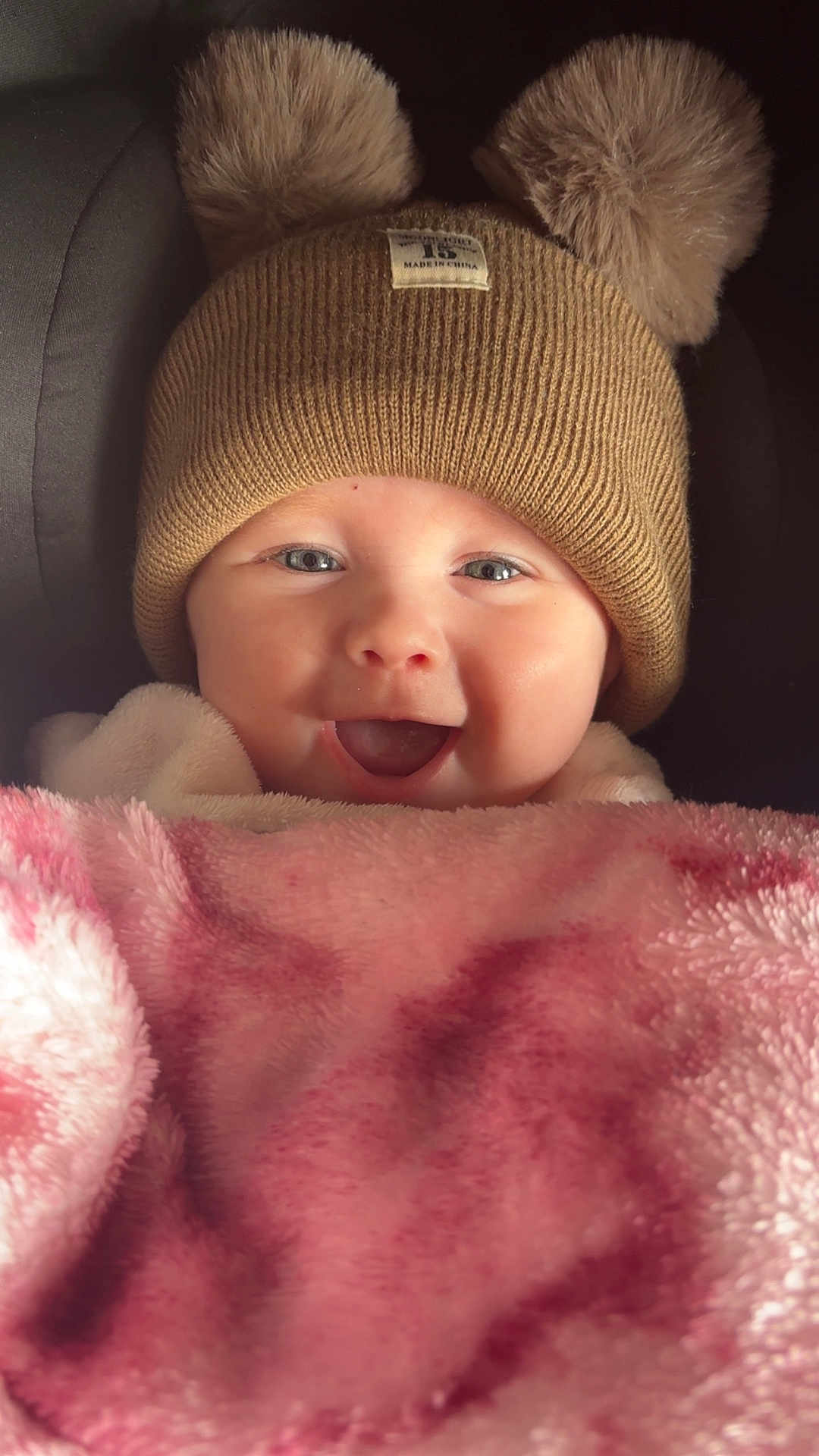 Mabel joined the competition — help win amazing prizes! baby, smiling, hat, pom_poms, blanket, pink, cozy, cute, face, infant, child, warm, happy, portrait, close_up, soft, clothing, headwear, indoor, person