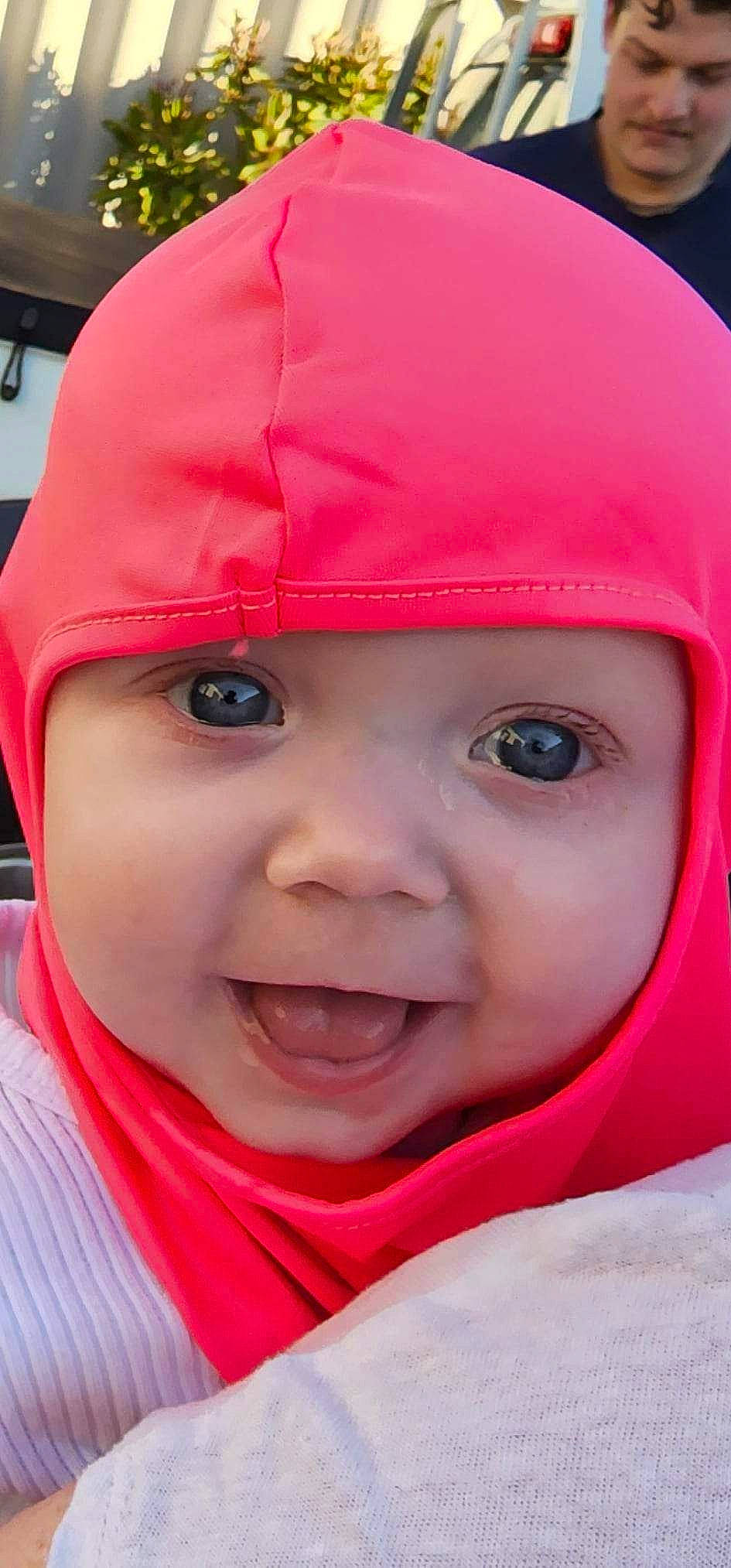 Alex is registered to the contest to win money with this photo: baby, cap, cheek, chin, clothing, cool, eye, eyebrow, facial_expression, happy, headgear, headwear, lip, mouth, nose, outerwear, person, photograph, pink, skin