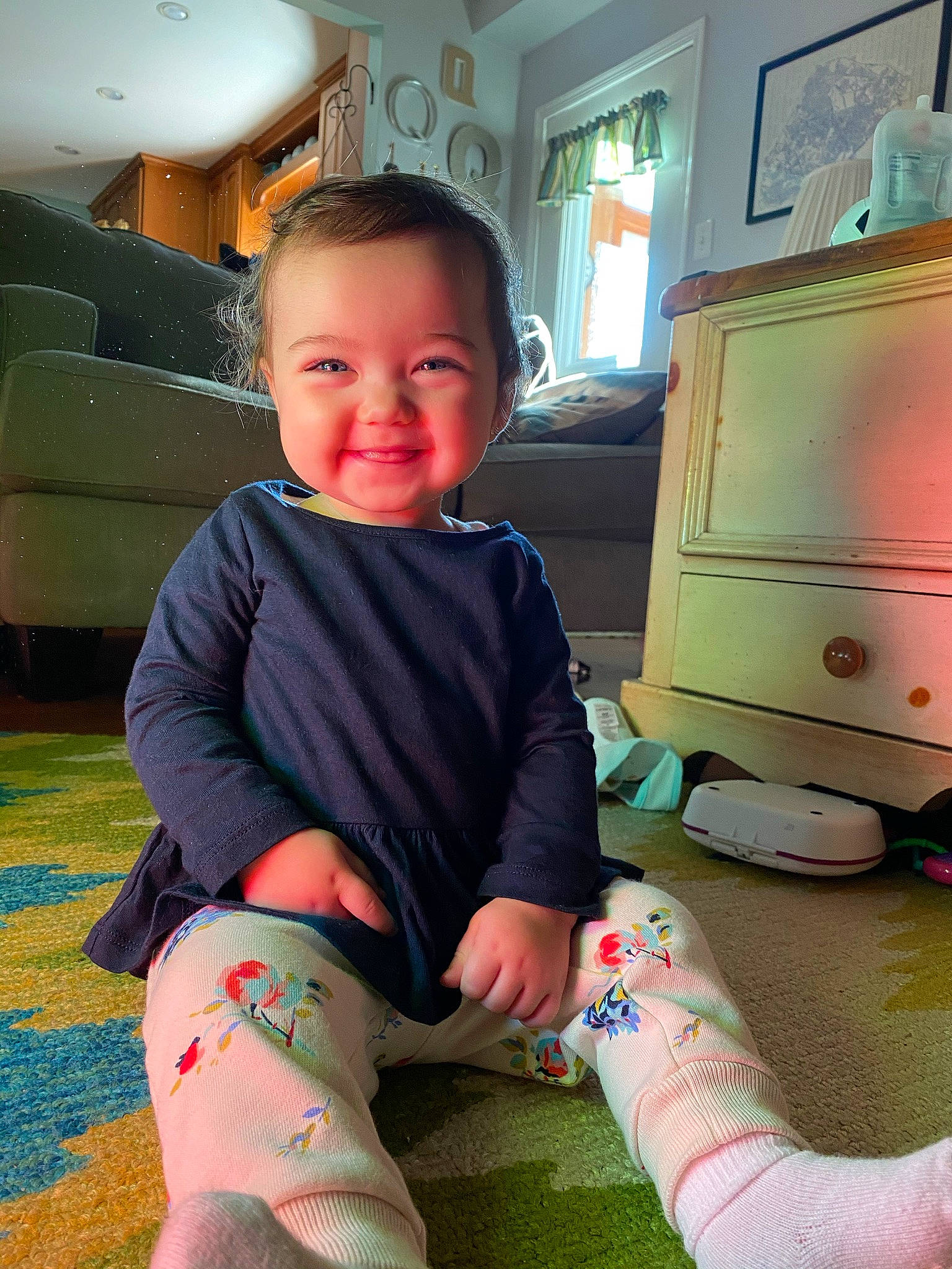 Leighla is registered to the contest to win money with this photo: baby_toddler_clothing, cabinetry, child, elbow, foot, fun, green, happy, human_leg, joint, joy, knee, lap, leg, person, skin, sleeve, smile, sock, standing