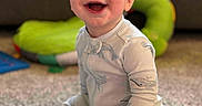 Jedidiah is registered to the contest to win money with this photo: baby, child, smiling, indoor, pajamas, carpet, book, toy, blanket, happy, face, person, infant, cute, playing, soft, cozy, young, sitting, home