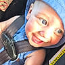 Jedidiah is registered to the contest to win money with this photo: baby, child, car_seat, blue_hoodie, smiling, happy, sunlight, safety_belt, infant, face, eyes, arm, clothing, seatbelt, car_safety, warning_label, heart_shape, cute, portrait, closeup