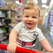 Levy joined the competition — help win amazing prizes! baby, toddler, child, shopping_cart, smile, blue_eyes, clothing, shirt, hair, hand, grocery_store, aisle, blurred_background, indoor, happy, portrait, cute, person, retail, shopping