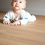 Léopold a rejoint le concours — aidez-le/la à gagner de superbes lots ! baby, child, infant, floor, wooden_floor, sweater, white_clothing, blue_spots, face, eyes, hands, crawling, indoor, light, expression, curious, portrait, person, young_child, skin