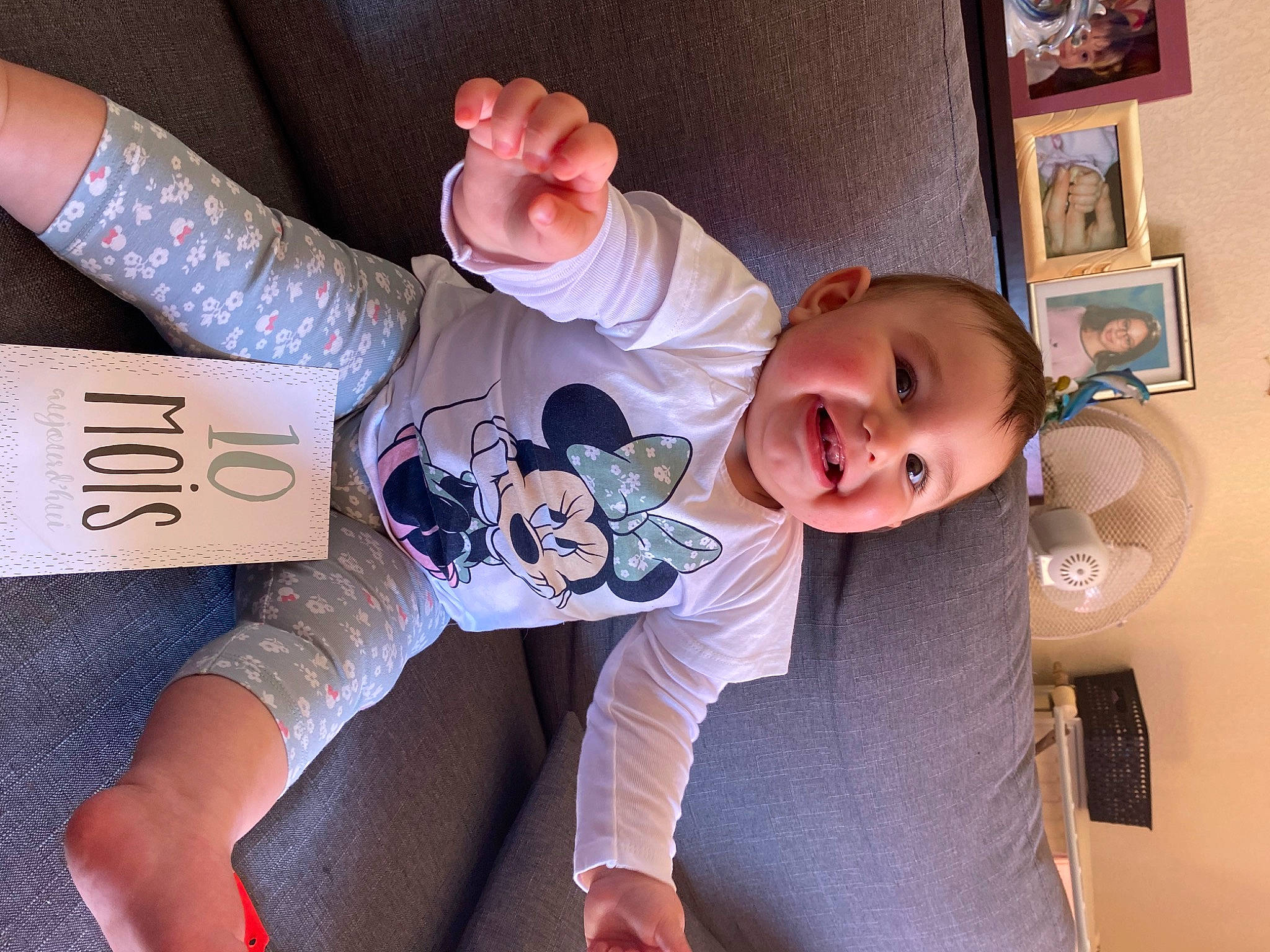 Eliana participe au concours pour gagner de l'argent avec cette photo : arm, baby, comfort, drinkware, facial_expression, finger, gesture, hand, happy, human_body, joint, joy, knee, leg, mouth, person, picture_frame, product, skin, sleeve