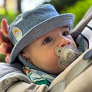 Elias participe au concours pour gagner de l'argent avec cette photo : baby, denim_hat, pacifier, close_up, face, outdoor, child, cute, infant, portrait, hat, apparel, headwear, peaceful, colorful, fabric, nature, soft_focus, young_child, expression