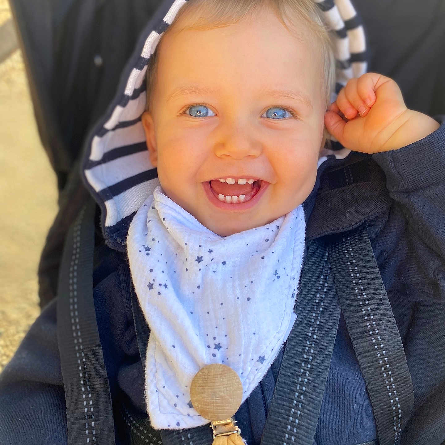 Charlie a rejoint le concours — aidez-le/la à gagner de superbes lots ! accessory, baby, baby_bib, blue_eyes, child, clothing, cute, face, hand, happy, harness, hood, infant, jacket, outdoor, portrait, smiling, striped, stroller, toddler