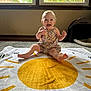 baby, carpet, child, clothing, cute, floor, greenery, happy, home, indoor, infant, natural_light, pet_carrier, playful, portrait, sitting, smiling, sun_pattern, towel, window
