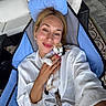 Luna joined the competition — help win amazing prizes! woman, cat, kitten, smile, chair, outdoor, casual_clothing, blonde_hair, pet, happy, relaxing, hand, face, portrait, furniture, pillow, patterned_rug, stone_floor, earrings, nail_polish