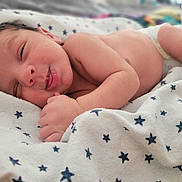 Kylin is registered to the contest to win money with this photo: baby, newborn, sleeping, blanket, star_pattern, diaper, infant, cute, soft, peaceful, skin, hand, face, portrait, lying_down, rest, cozy, child, closeup, comfort