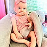 baby, child, pink_dress, headband, plush_toy, bunny, armchair, couch, blanket, curtain, indoor, cute, smiling, sitting, person, portrait, soft_toy, toddler, happy, cozy