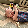 Ember joined the competition — help win amazing prizes! baby, infant, child, smiling, headband, dress, toy, giraffe_toy, playmat, pattern, indoor, happy, young_child, person, cute, lying_down, playpen, colorful, soft_focus, cheerful