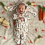Xyleek is registered to the contest to win money with this photo: baby, smiling, carrot_onesie, bunny_ears, toy_carrots, toy_radishes, fluffy_carpet, infant, cute, happy, lying_down, child, playful, indoors, soft_texture, adorable, small_hands, face, cozy, fun