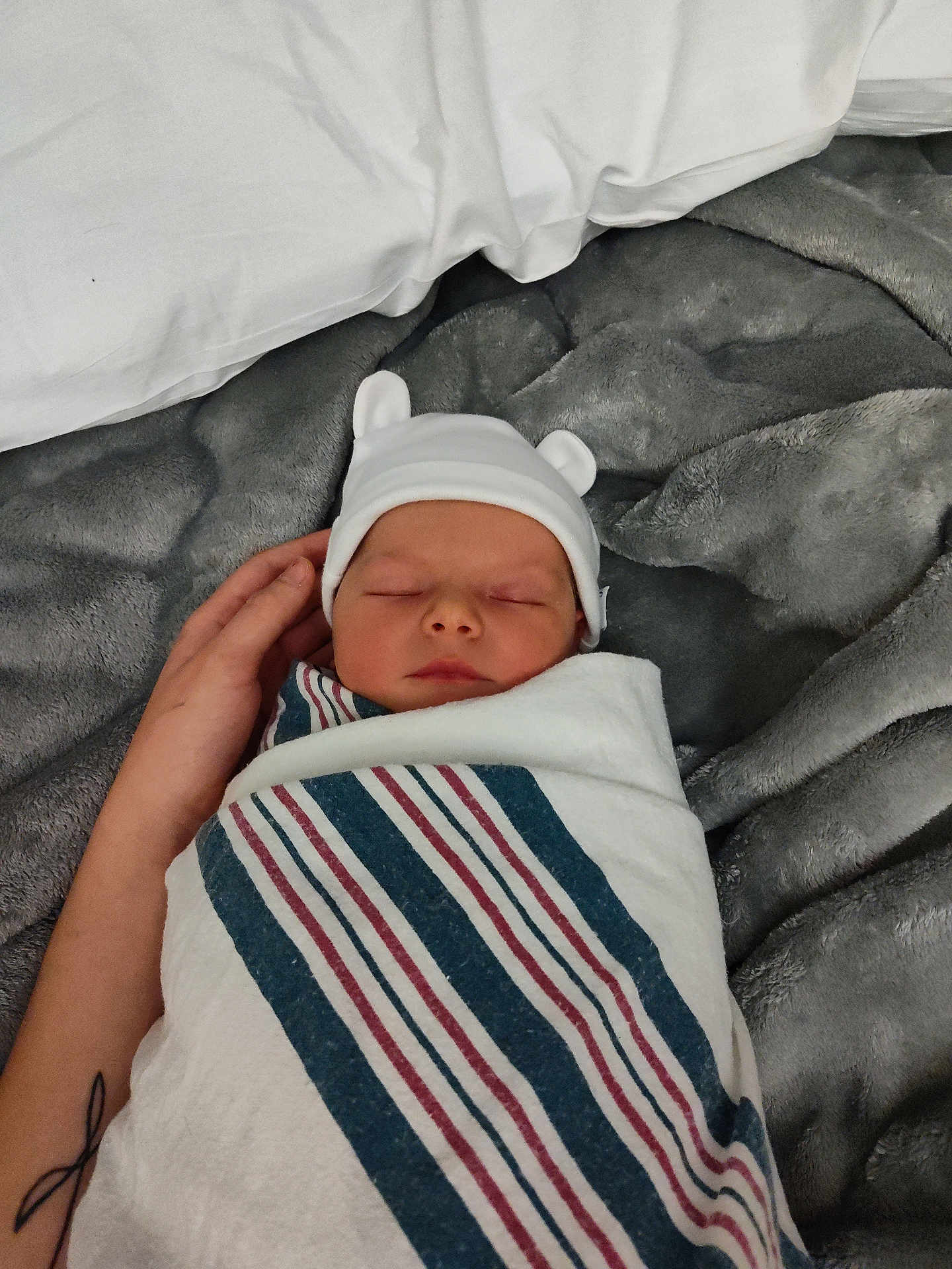 Koda is registered to the contest to win money with this photo: newborn, baby, sleeping, hat, striped_blanket, hand, tattoo, grey_blanket, soft_texture, wrapped, infant, bed, resting, cute, peaceful, person, cozy, portrait, indoors, sleep