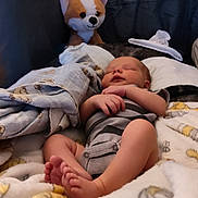 Koda is registered to the contest to win money with this photo: baby, sleeping, blanket, plush_toy, soft, bed, infant, cozy, comfort, peaceful, child, indoor, cute, resting, foot, hand, pajamas, stuffed_animal, napping, relaxation