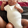 baby, infant, onesie, socks, bed, blanket, patterned_sheet, person, skin, cute, child, lying_down, fist, comfortable, indoors, young, portrait, sleepwear, resting, human
