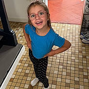 Rose a rejoint le concours — aidez-le/la à gagner de superbes lots ! child, girl, smile, glasses, tiara, blue_shirt, leggings, polka_dots, socks, indoor, tiled_floor, doorway, shoes, home, happy, posing, person, standing, young, eyewear