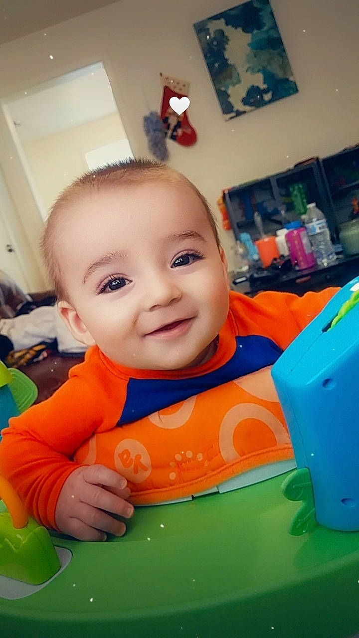 Maverick is registered to the contest to win money with this photo: baby, baby_playing_with_toys, baby_products, baby_toddler_clothing, cheek, child, eyebrow, finger, flooring, fun, happy, iris, leisure, mouth, nose, orange, person, picture_frame, recreation, smile