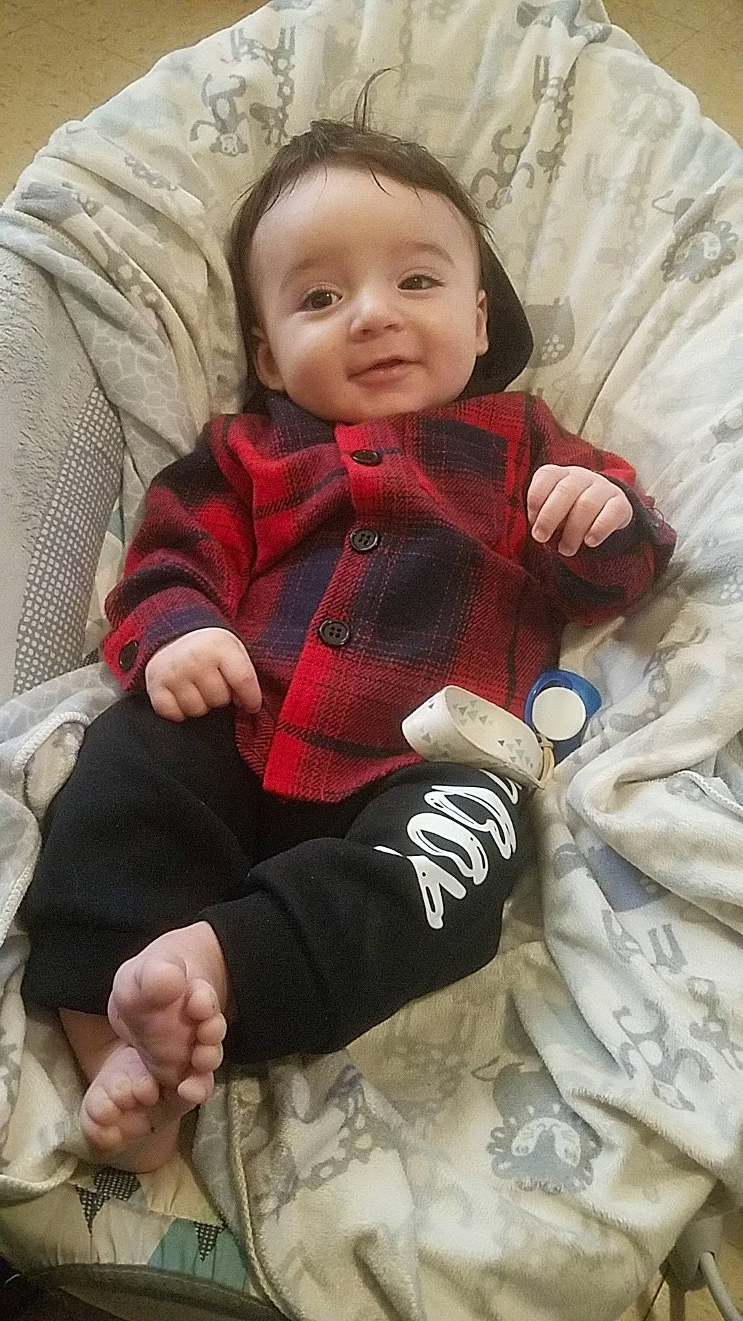 Maverick is registered to the contest to win money with this photo: baby, baby_toddler_clothing, cheek, comfort, eye, face, finger, hairstyle, hand, head, human_body, jacket, lap, leg, outerwear, person, skin, sleeve, smile, textile