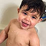 child, baby, toddler, smile, bath, bathtub, wet_hair, water_droplets, happy, chubby_cheeks, skin, bathroom, face, eyes, mouth, black_hair, close_up, portrait, playful, faucet