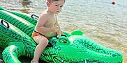 Ahadov Davud a rejoint le concours — aidez-le/la à gagner de superbes lots ! child, toddler, inflatable, crocodile, water, lake, beach, summer, outdoor, sunlight, nature, trees, play, fun, swimwear, sand, reflection, person, water_toy, recreation