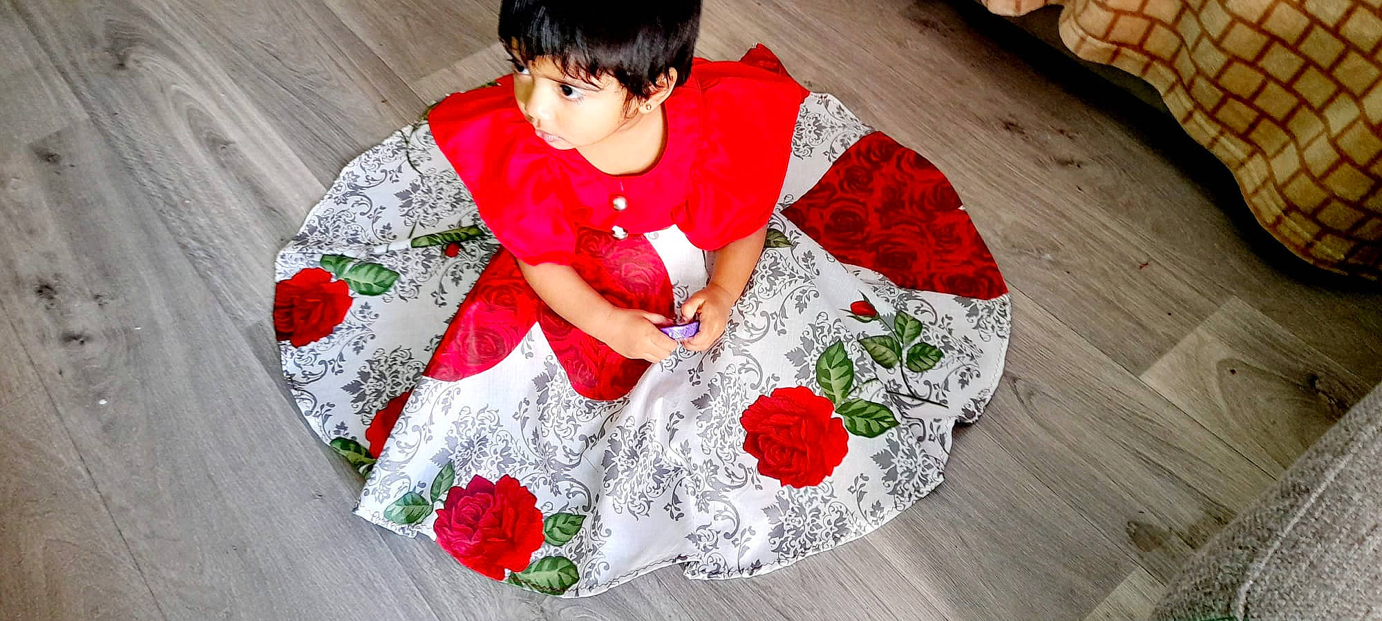Inia participe au concours pour gagner de l'argent avec cette photo : baby_toddler_clothing, carmine, child, event, flooring, floral_design, flower, happy, linens, magenta, pattern, person, petal, plant, red, sleeve, t_shirt, tablecloth, textile, toddler