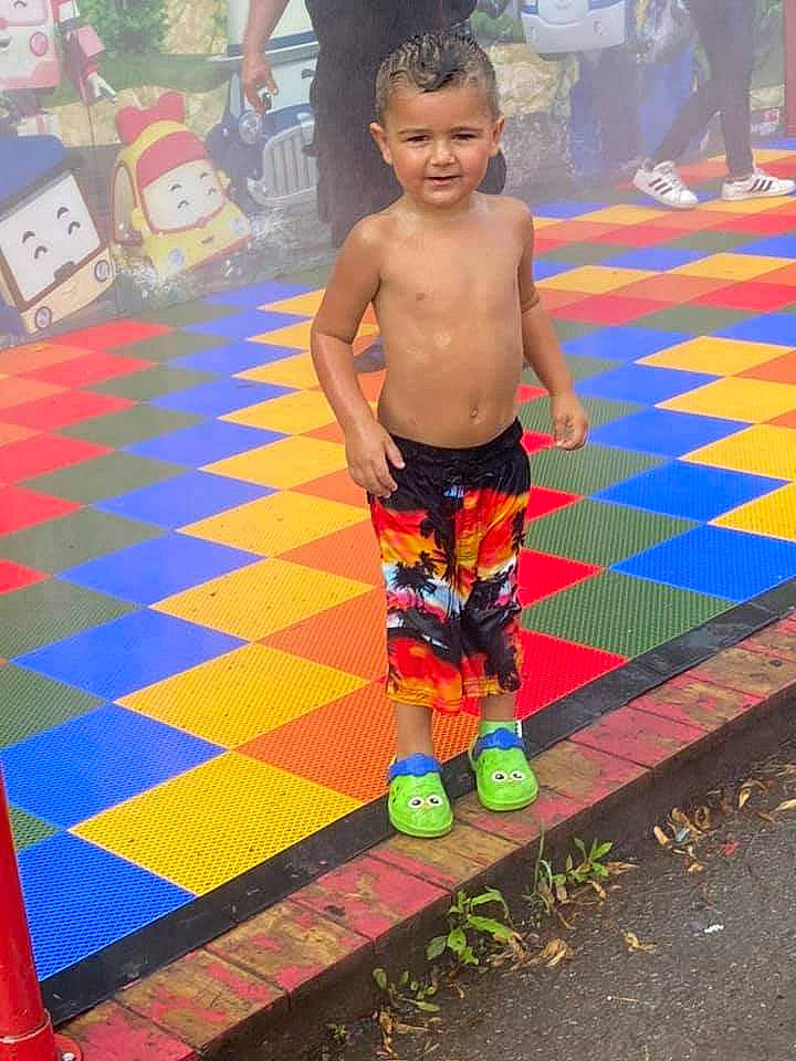 Willyam participe au concours pour gagner de l'argent avec cette photo : board_short, child, cool, electric_blue, flooring, fun, happy, human_leg, leisure, orange, pattern, person, recreation, shorts, t_shirt, textile, thigh, toddler, trunks, water