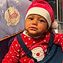 toddler, child, baby, santa_hat, red_clothing, polka_dots, high_chair, winnie_the_pooh, indoor, curious, face, expression, hand, seat, festive, holiday, cute, smiling, person, portrait